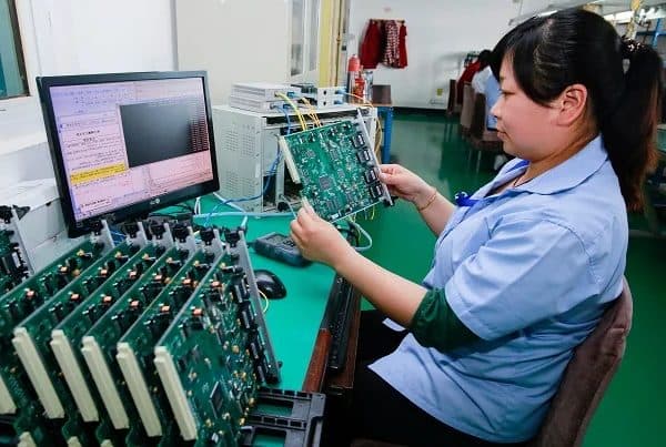 Electronics quality control, technician testing printed circuit boards