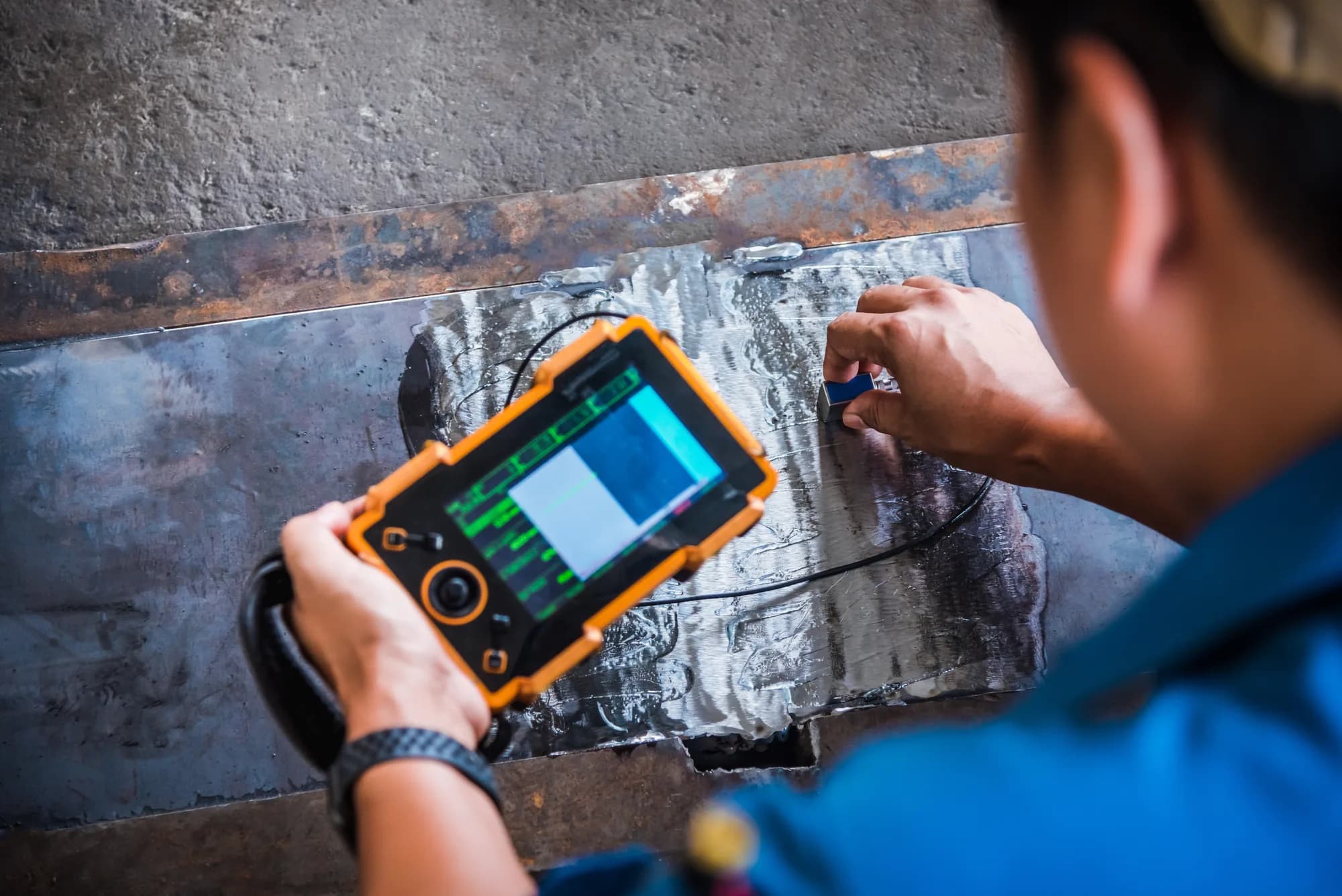 Inspector performing ultrasonic weld testing on fabricated steel